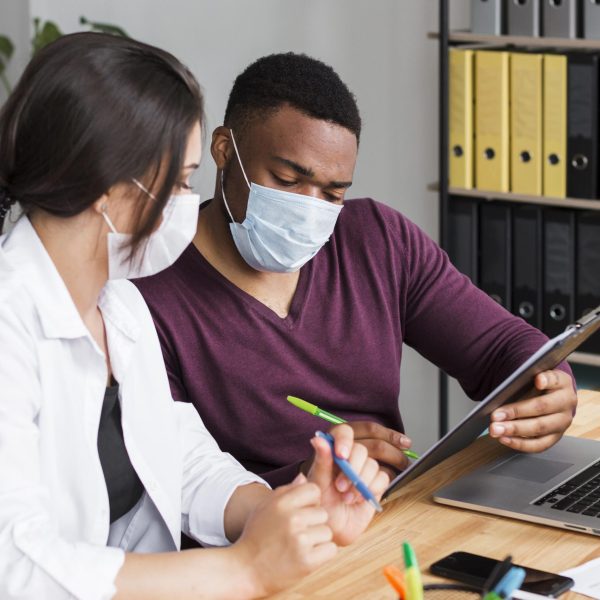 two-workers-office-pandemic-wearing-medical-masks